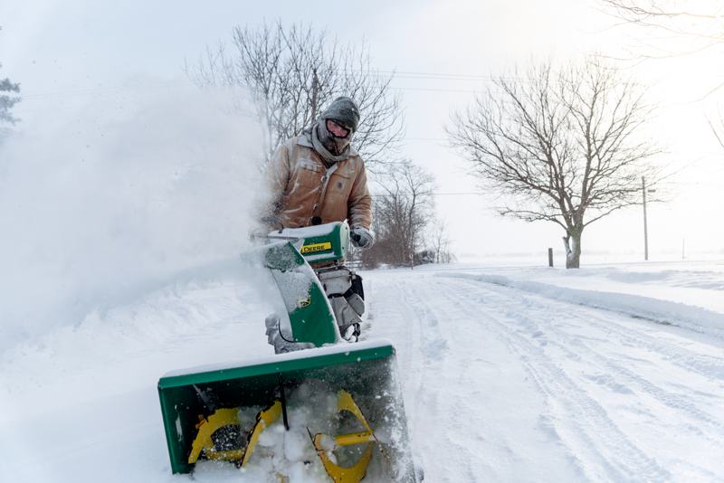 Man clearing snow with a two-stage snow blower