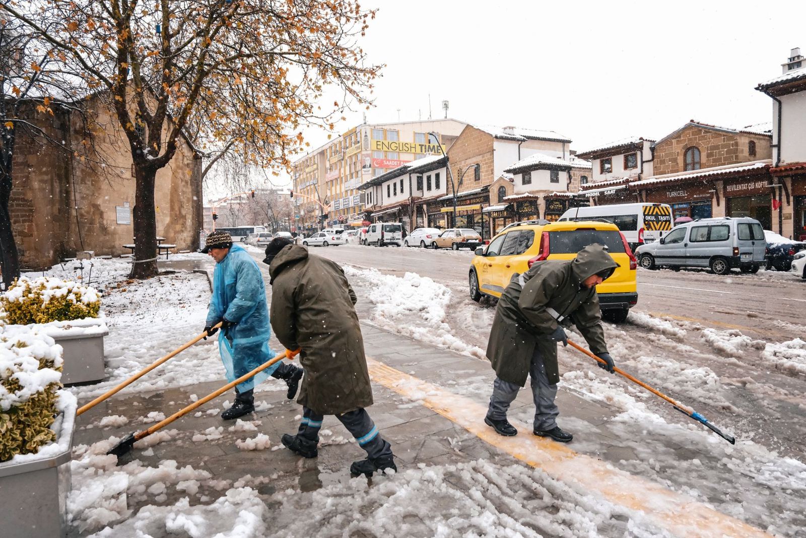Crew clearing snow from a city sidewalk in winter